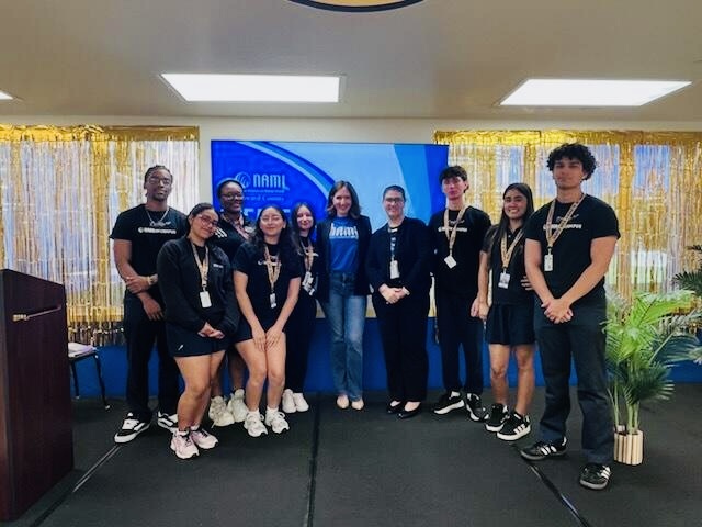 Erika Marcus on stage with a group of students and volunteers after a session